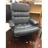 A Pieffe style reclining armchair with grey buttoned leather upholstery.