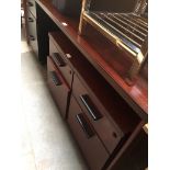 A large mahogany desk with a pair of filing cabinets