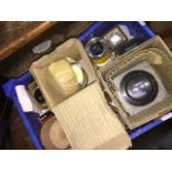 A box of various antique camera lenses.