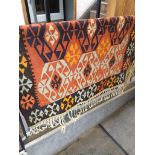 An orange, brown and cream geometric pattern eastern carpet, 180cm x 122cm.