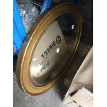 An oval gilt framed mirror