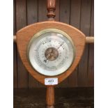 A barometer set in shield shaped wood