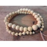 A single strand of ivory beads circa 1900, restrung with 9ct gold clasp, length 57cm.