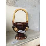 A slipware basket with pedestal foot and loop handle decorated with applied yellow lattice work