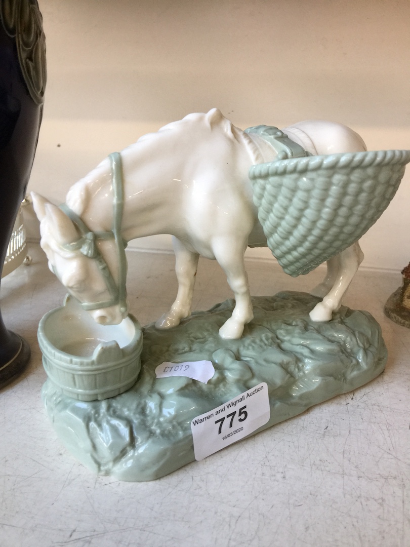 A Royal Doulton figure of a cream coloured pack horse on a pale green base drinking from a water