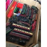 A box of model railway locomotives and other related items.