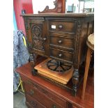 A small aged oak cabinet with carved panel door