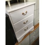 A pair of white bedside cupboards