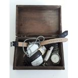 A wooden box containing three wristwatches and a whistle.