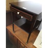 A 2 tier small mahogany table with single drawer on brass castors