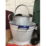 An enamelled washing bowl and a galvanised watering can.
