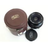 A Carl Zeiss Jena F+28mm 1:28 MC 49 lens with case.