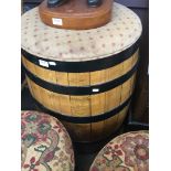 A large metal bound barrel with upholstered top.