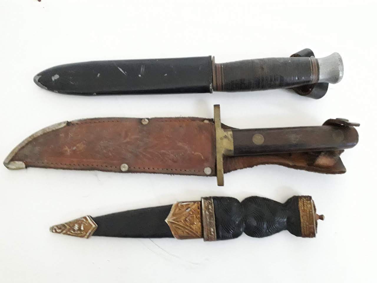 A group of three knives comprising a Scottish dirk, a German scout type knife and a bowie knife.