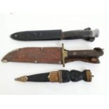 A group of three knives comprising a Scottish dirk, a German scout type knife and a bowie knife.