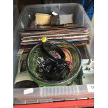 A crate of bric a brac and collectables including mantle clocks, wristwatches, and other items.