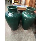 A pair of large glazed green urns.