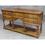 A good quality reproduction crossbanded oak sideboard with five drawers having gilt brass swan