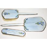 A silver and enamel dressing table set comprising hand mirror and two brushes, Charles S. Green &