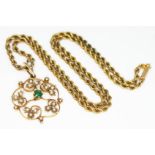 An Edwardian drop pendant of floral form and set with seed pearls and a central emerald, length