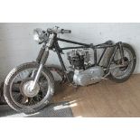 A quantity of part assembled 1950s Triumph 650 motorcycle parts including frame, forks, wheels,