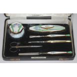 A vintage enamelled and gilt metal cased manicure set.