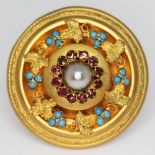 A Victorian target brooch circa 1880 with central pearl, surround by purple stones and a grape and