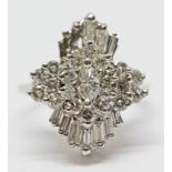 An Art Deco style diamond cluster ring, set in white metal , indistinctly marked, gross wt. 5.82g,