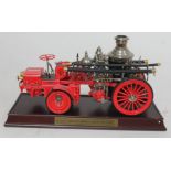 A Franklin Mint 1912 Christie Front Drive Steamer fire engine model on wooden plinth.