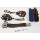 A mixed lot comprising two miniature tortoiseshell mandolins, an amber cheroot holder, a cigar