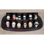 A set of 12 miniature Royal Doulton character jugs with stand.