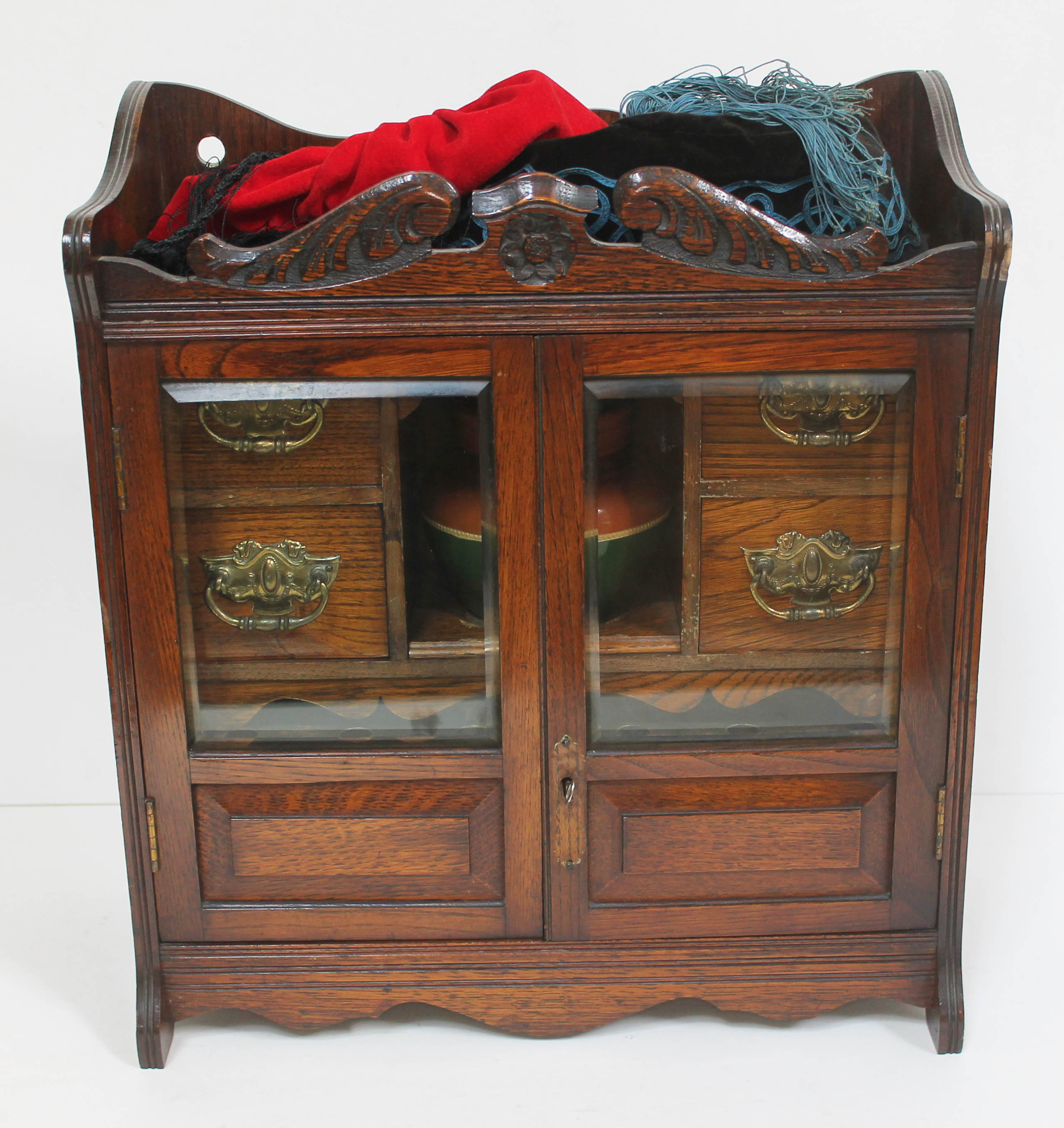 An Edwardian smokers cabinet and accessories including pot, vintage pipes and smoking caps.