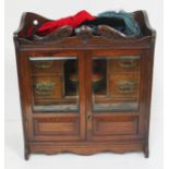 An Edwardian smokers cabinet and accessories including pot, vintage pipes and smoking caps.