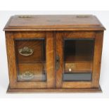 An Edwardian oak smokers cabinet with hinged top, and three interior drawers, one marked "Cards",