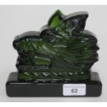 A green pressed glass doorstop in the form of a wolf's head.