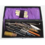 A case containing various penknives, propelling pencils and a fountain pen, button hooks etc.