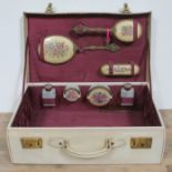 A vintage vanity case complete with brushes, mirror, bottles and powder jars.