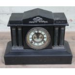 A late Victorian black slate architectural mantel clock with visible Brocot type escapement,