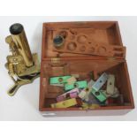 A brass microscope marked H Crouch, 54 London Wall, London, 440, with wooden box and various slides.