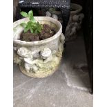 2 concrete planters decorated with cherubs