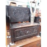 A carved oak monk's bench.