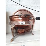 A collection of copperware including tray, dish, and pan on stove