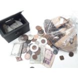 A small cash box with various world coins and notes and a bag of pennies