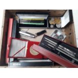 A box of pens, coins and penknives