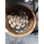 A wicker log basket with a roll of garden edging