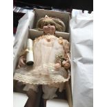 A large boxed porcelaine doll and another