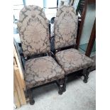 A pair of high back upholstered chairs.