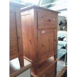 A pine bedside cabinet.