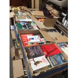 A table top comprising 9 boxes of books and a box of DVDs