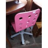 A child's pink swivel chair.